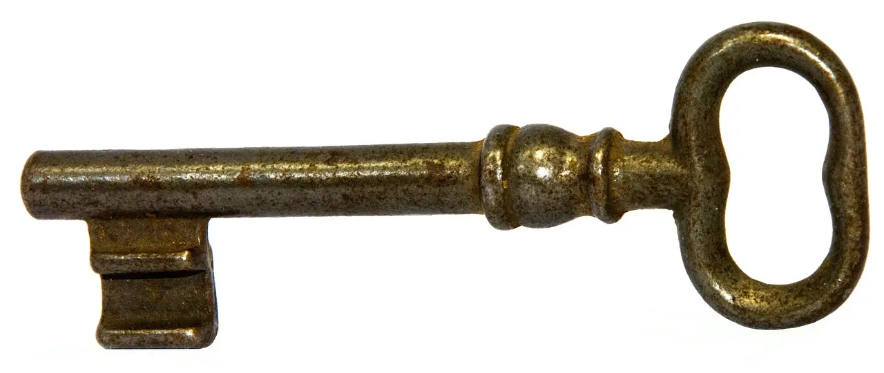 An old rusty iron key on a white background
